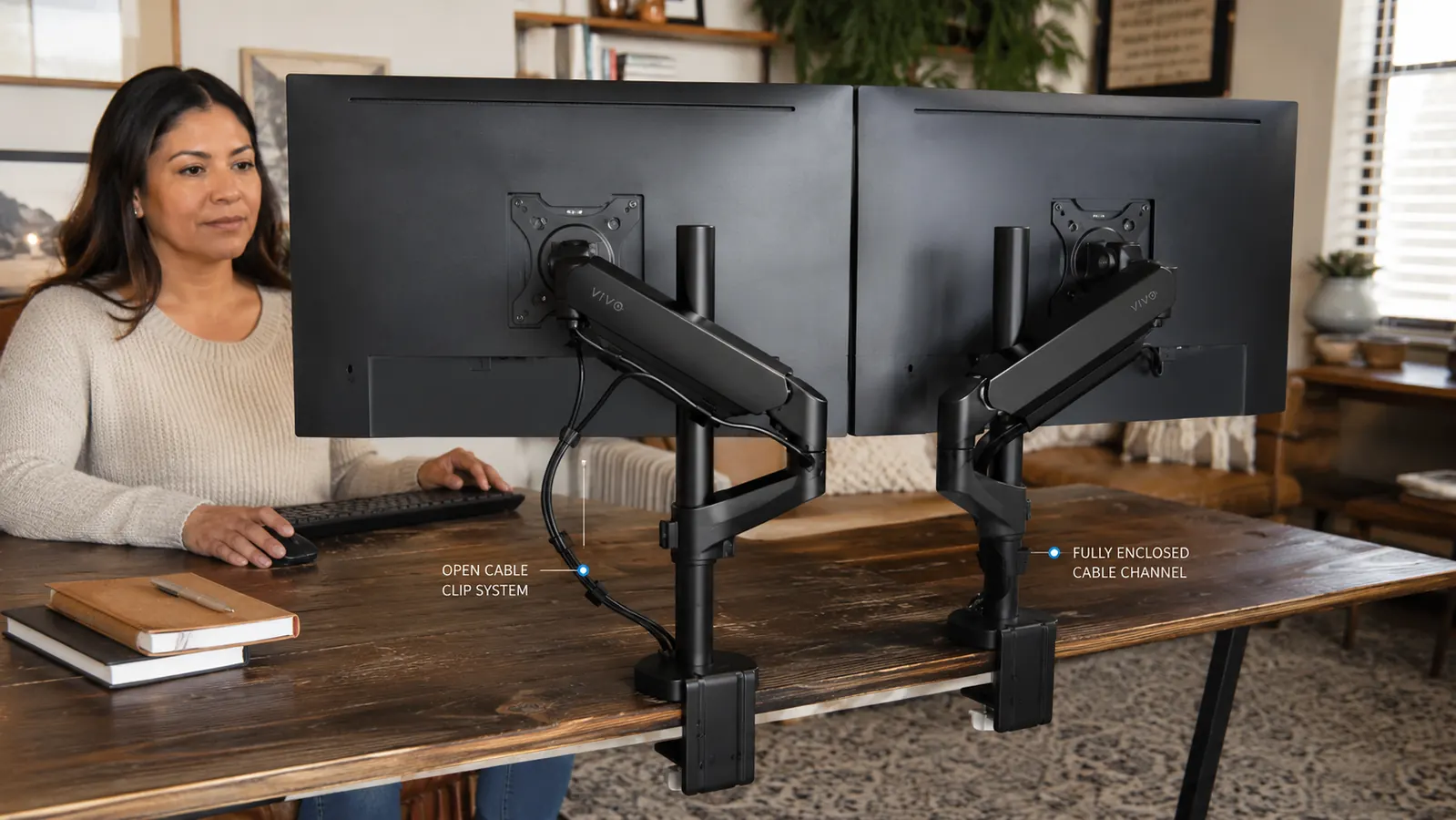 Two monitor arms side by side showing different cable management designs, one with a simple clip, one with a fully enclosed channel